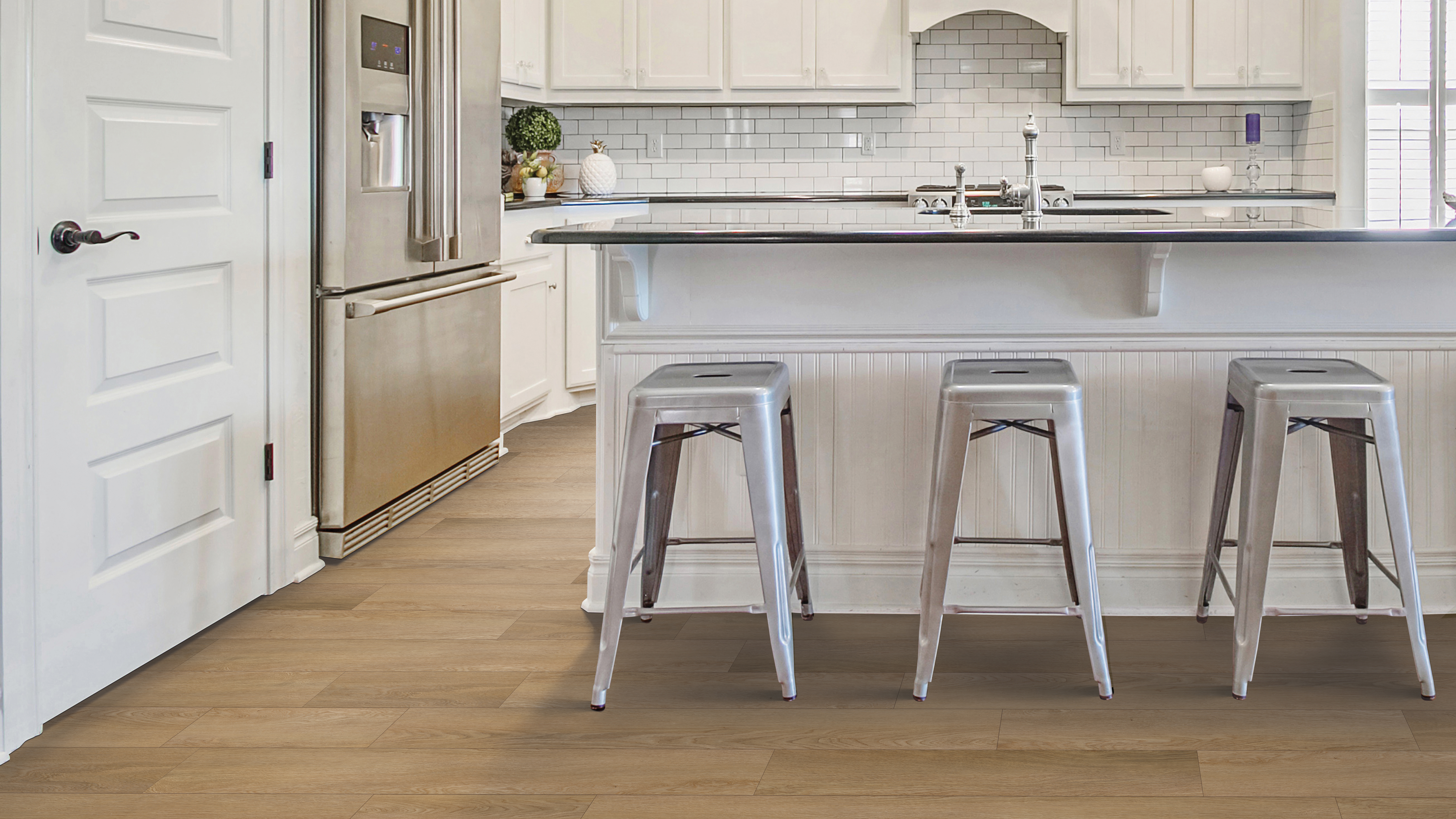 warm, golden toned wood look luxury vinyl plank flooring in an open concept kitchen with white cabinets and a center island
